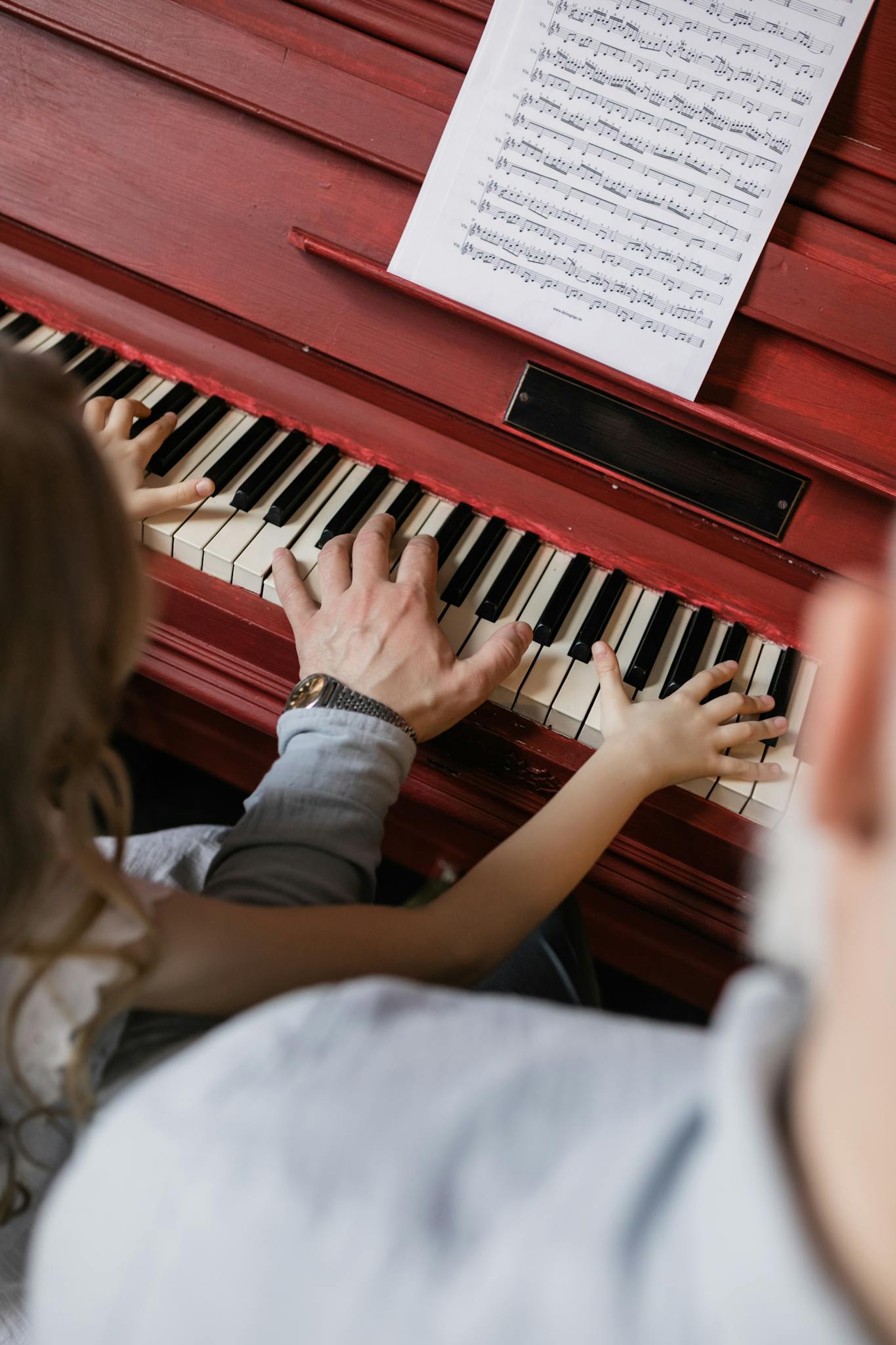 People Playing Piano with Sheet Music