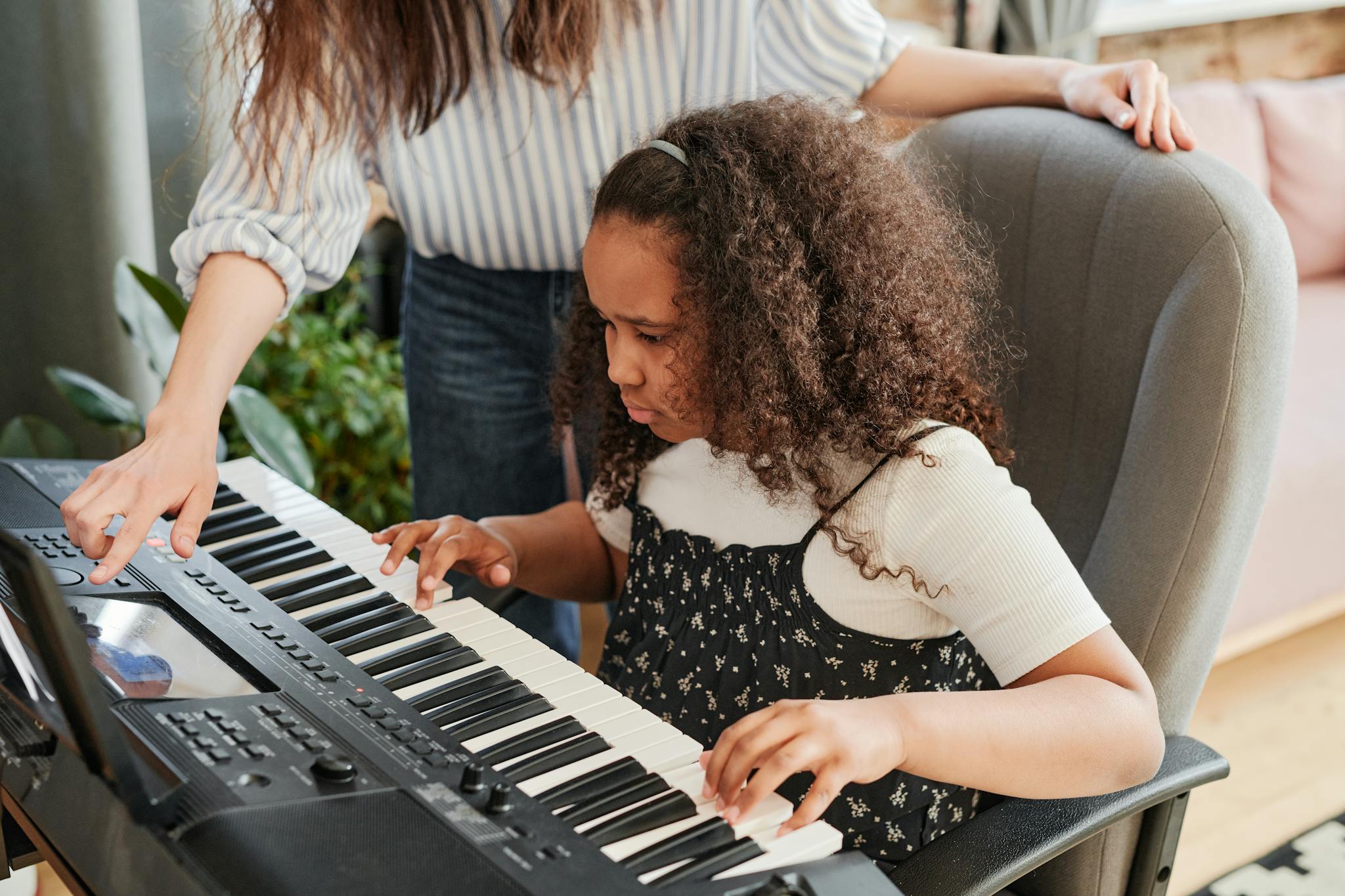 Person Teaching the Girl How to Play a Piano